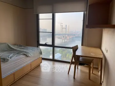 Cozy bedroom with stunning city view and natural light, perfect for urban living.