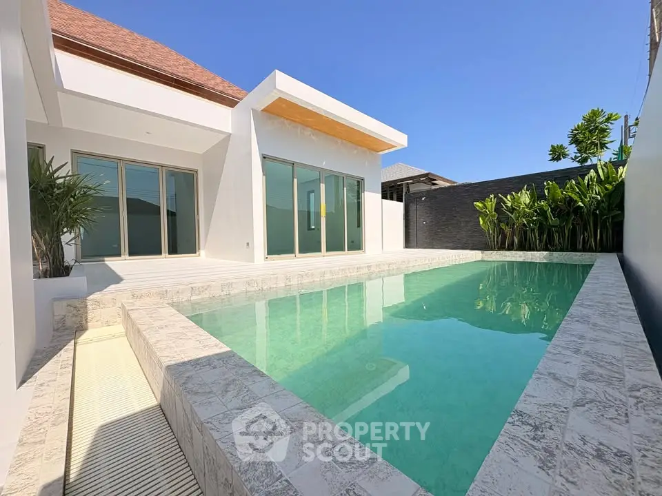 Modern villa with private pool and sleek design under clear blue sky.