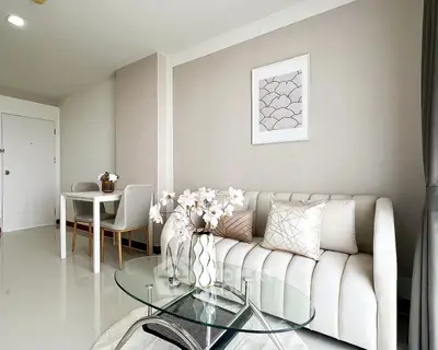 Modern living room with elegant decor and glass coffee table in a stylish apartment.