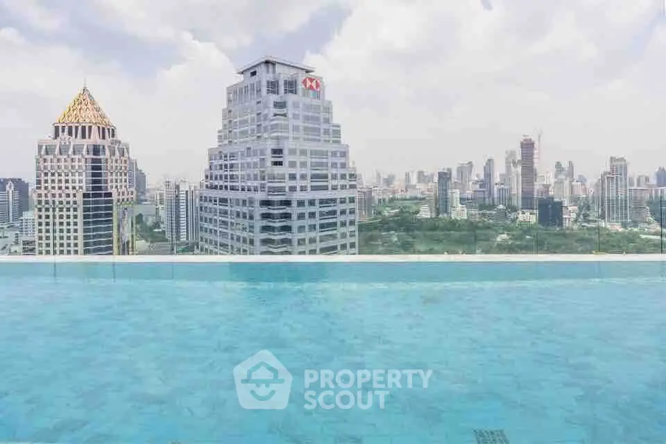 Stunning rooftop pool with panoramic city skyline view in luxury high-rise building.
