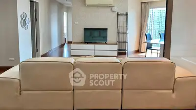 Spacious living room with modern decor and balcony view in a high-rise apartment.