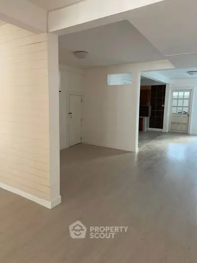 Spacious open-plan living area with light wood flooring and modern finishes.