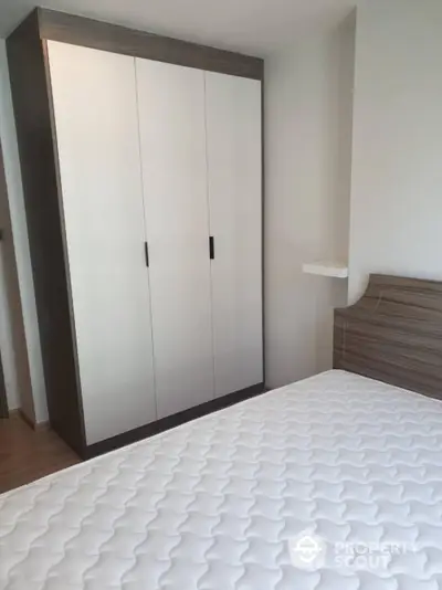 Modern bedroom with sleek wardrobe and comfortable mattress in stylish apartment.