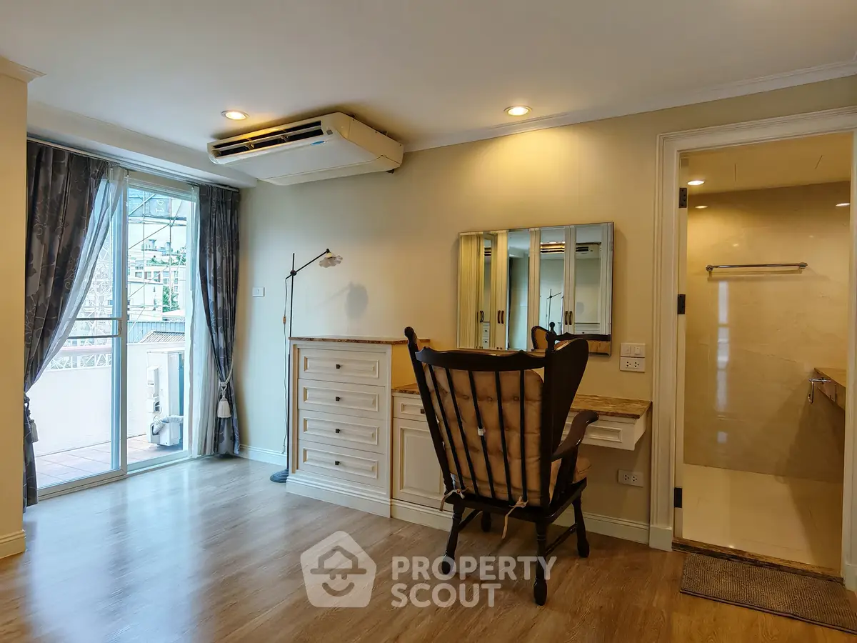 Spacious bedroom with elegant wooden flooring and balcony access