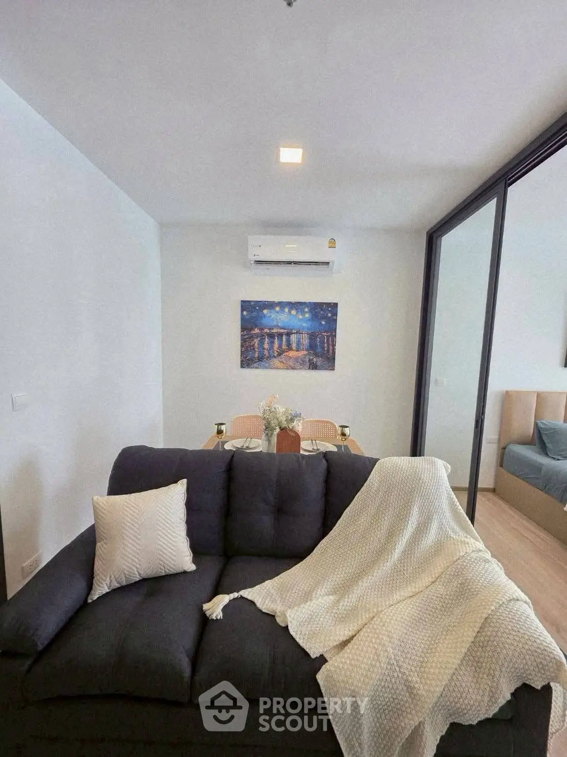 Modern living room with cozy sofa and dining area in open-plan apartment