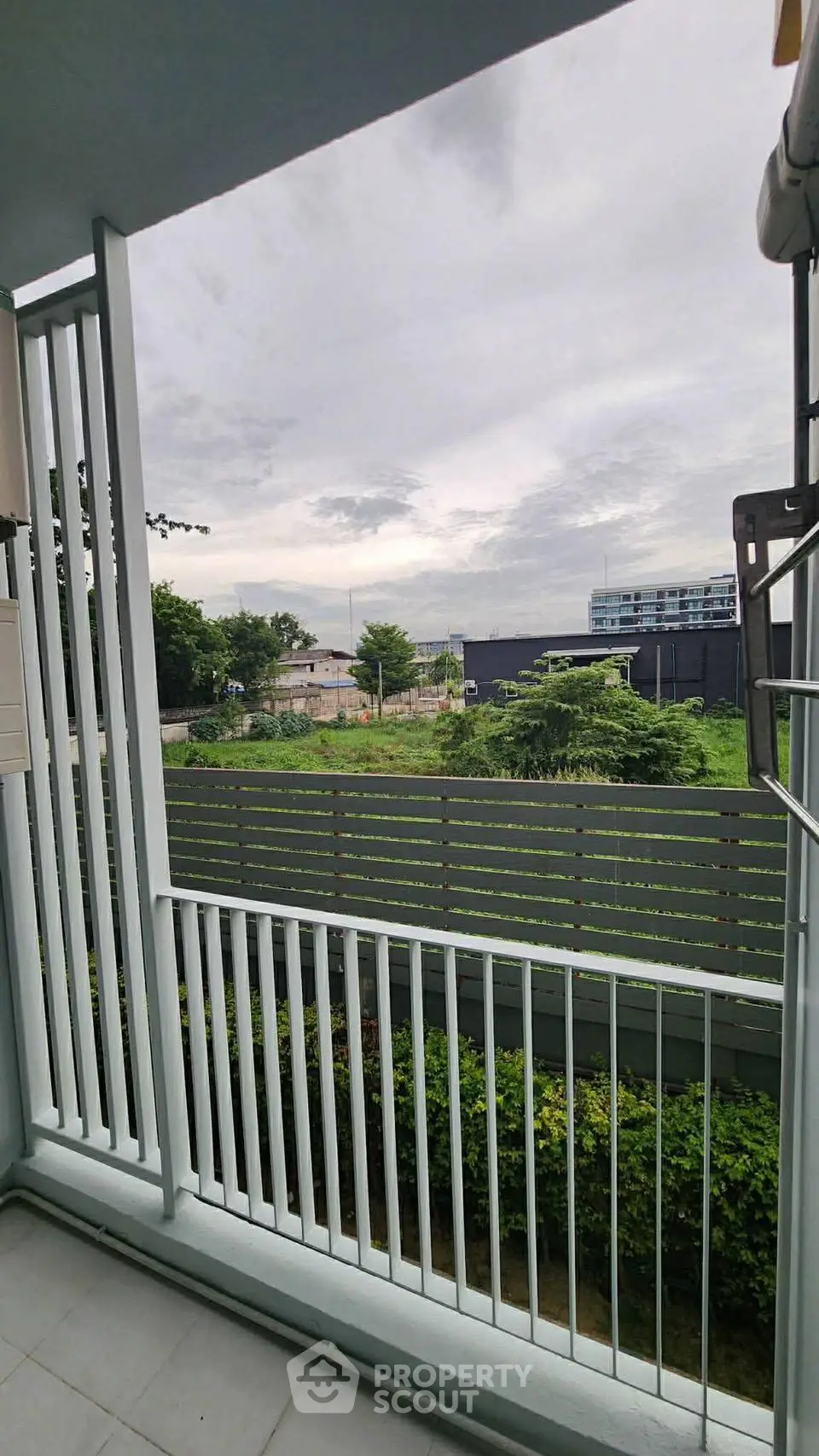 Charming balcony view with lush greenery and serene surroundings, perfect for relaxation and enjoying nature.