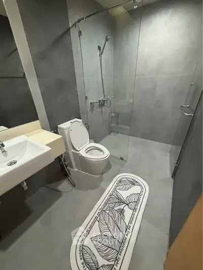 Modern bathroom with sleek design and glass shower enclosure in contemporary apartment.