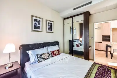 Elegant bedroom with mirrored wardrobe and stylish decor in modern apartment