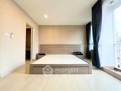 Spacious bedroom with modern design and large windows for natural light.