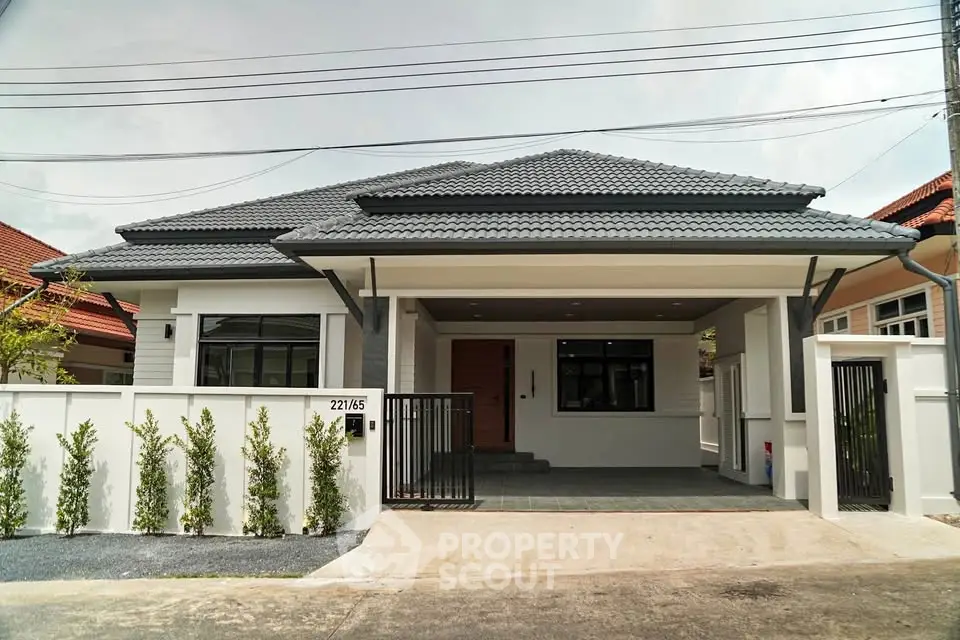 Modern single-story house with sleek design and spacious driveway in a serene neighborhood.