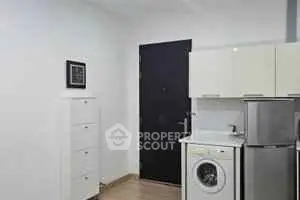 Modern apartment entrance with washing machine and sleek cabinetry