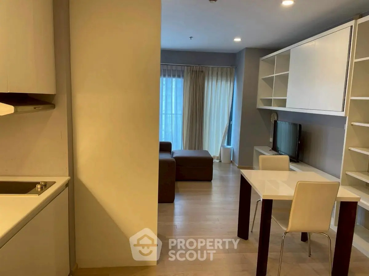 Modern open-plan living room with dining area and kitchen in stylish apartment.