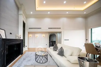 Luxurious living room with elegant decor and high ceilings, featuring a cozy fireplace and stylish furniture.