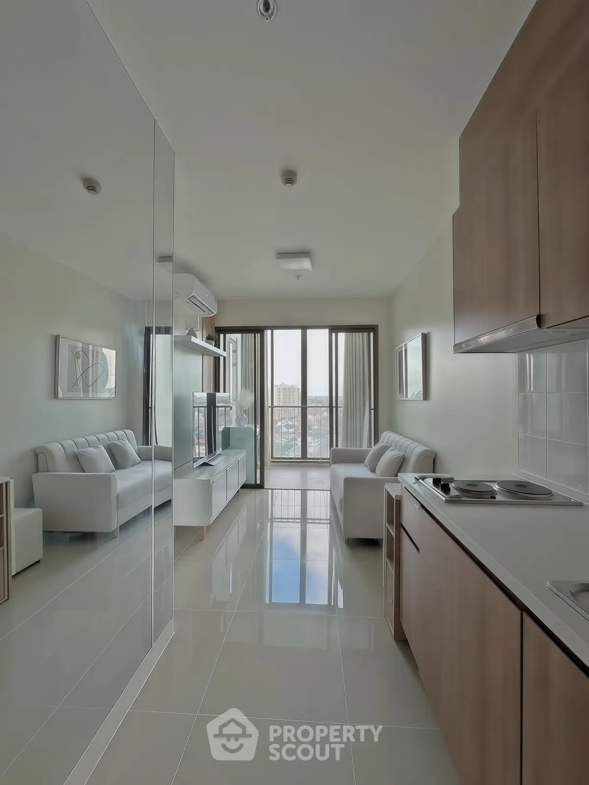 Modern open-plan living room with sleek kitchen and city view.