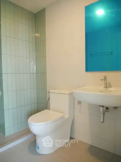 Modern bathroom with sleek fixtures and vibrant blue accent mirror