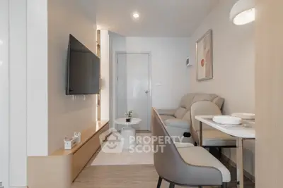 Modern living room with sleek furniture and wall-mounted TV in a cozy apartment.