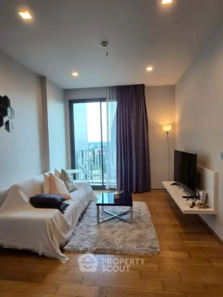 Modern living room with cozy decor and city view balcony access.