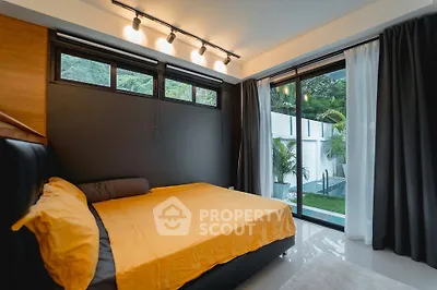 Modern bedroom with large windows and garden view, featuring sleek design and natural light.