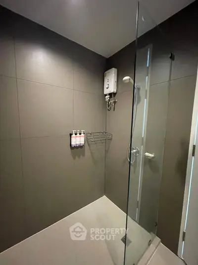 Modern bathroom with glass shower enclosure and wall-mounted water heater.