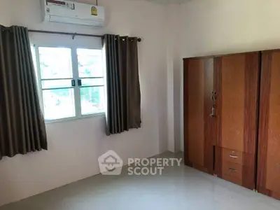 Spacious bedroom with natural light and wooden wardrobe