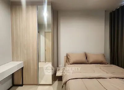 Modern bedroom with sleek wardrobe and cozy bedding in a minimalist design.