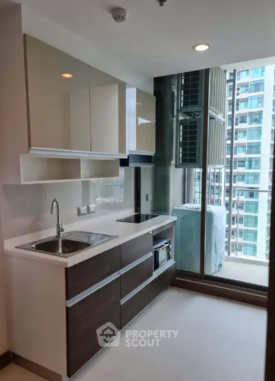 Modern kitchen with sleek cabinetry and city view from window, perfect for urban living.
