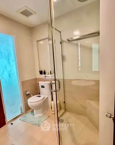 Modern bathroom with glass shower and sleek fixtures in a contemporary home.