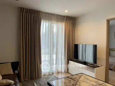 Modern living room with elegant curtains, flat-screen TV, and marble table in a cozy apartment setting.