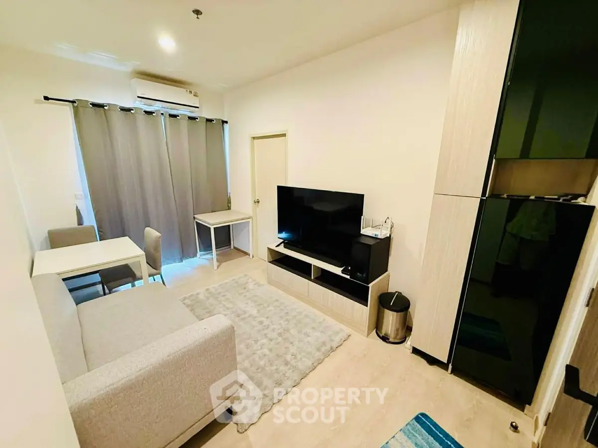 Modern living room with sleek furniture and entertainment setup in a cozy apartment.