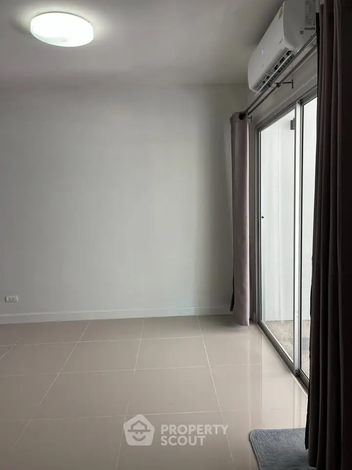 Spacious room with sliding glass doors and air conditioning, perfect for modern living.