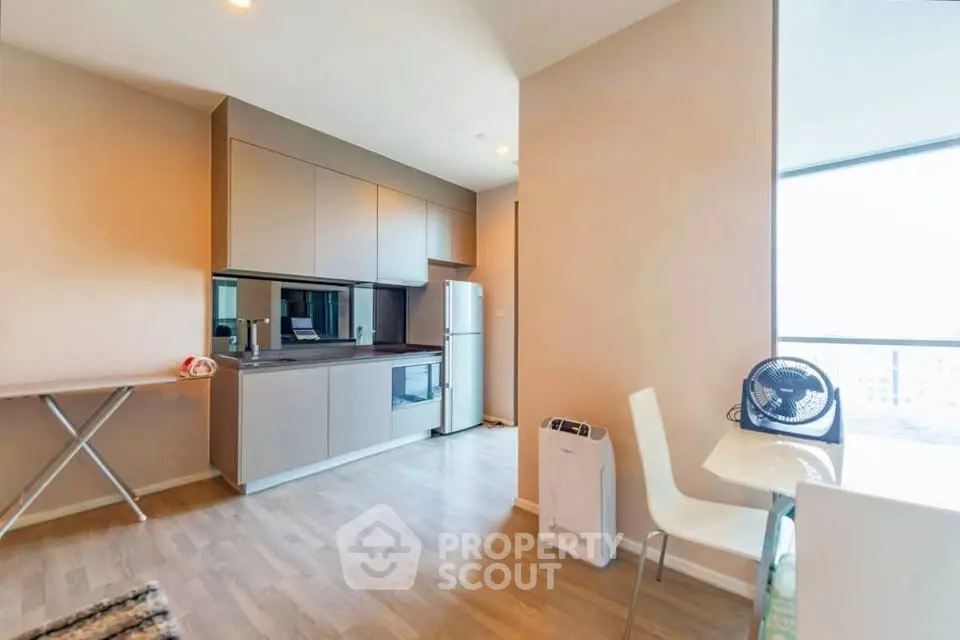 Modern kitchen with sleek cabinetry and dining area in a bright apartment