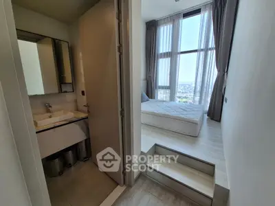 Modern apartment with bedroom and bathroom, featuring large windows and sleek design.