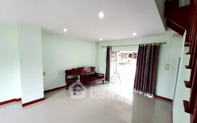 Spacious living room with elegant wooden sofa and large windows for natural light.