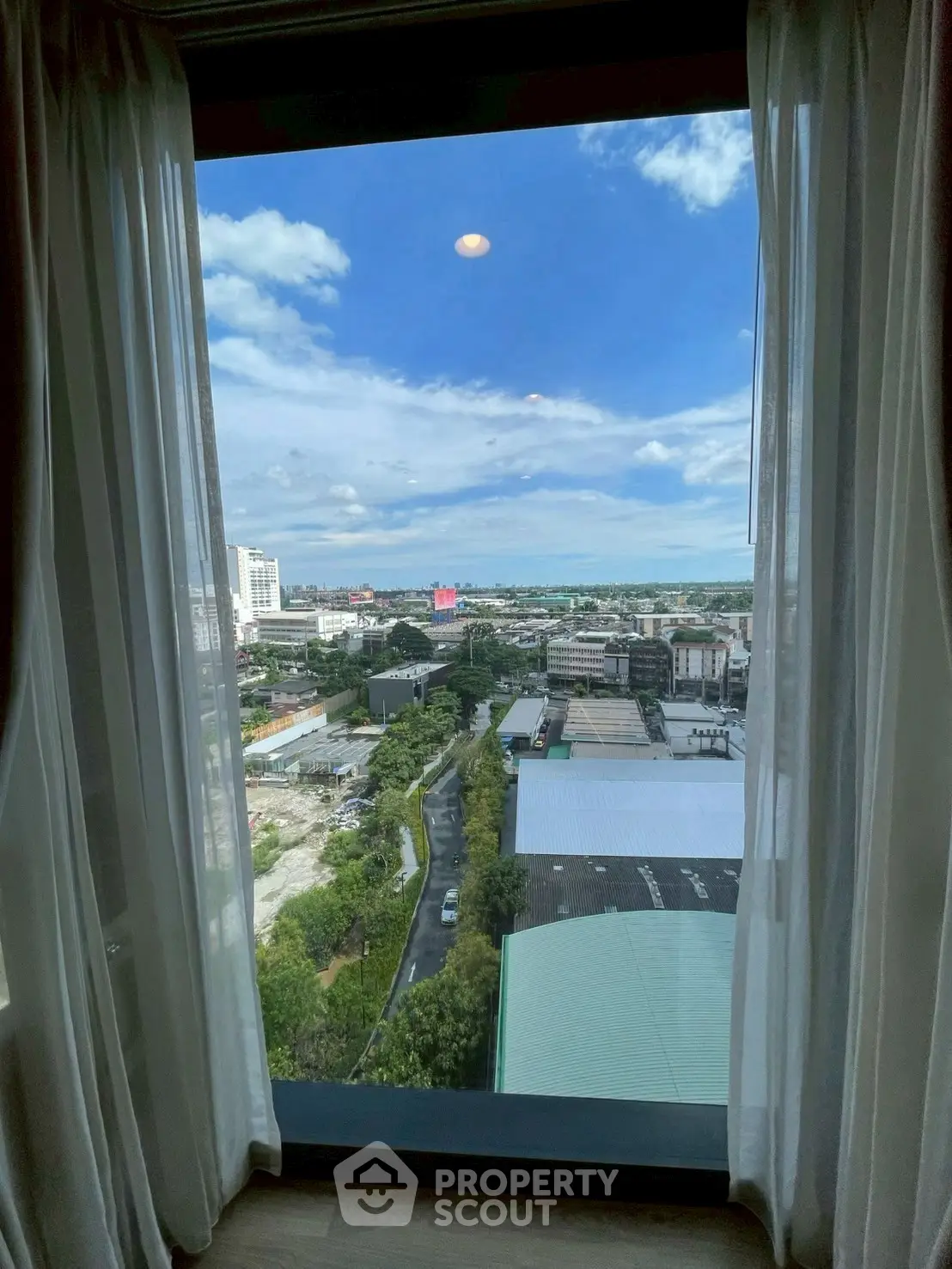Stunning cityscape view from a high-rise window with clear blue skies.