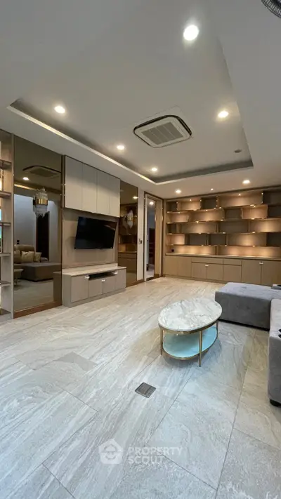 Spacious modern living room with elegant built-in shelves and stylish marble coffee table.