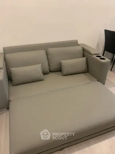 Modern gray sofa with cup holders in stylish living room setting