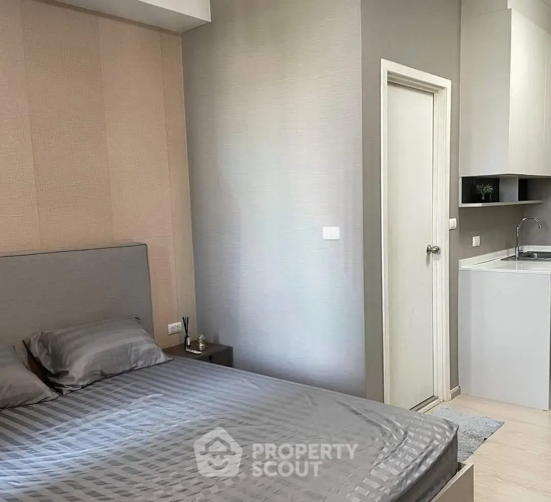 Modern bedroom with sleek design and compact kitchenette, perfect for urban living.