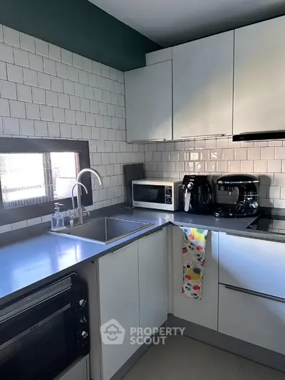 Modern kitchen with sleek white cabinets and stainless steel appliances