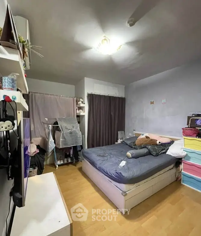 Cozy bedroom with modern decor and ample storage space, featuring a comfortable bed and stylish shelving.