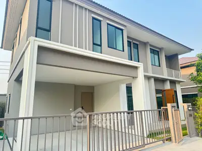 Modern two-story house with sleek design and spacious driveway in a serene neighborhood.