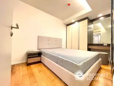 Modern bedroom with stylish furniture and wooden flooring in a cozy apartment.