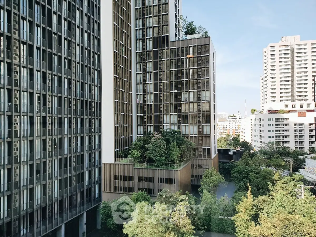 Modern high-rise building with lush greenery and urban skyline view