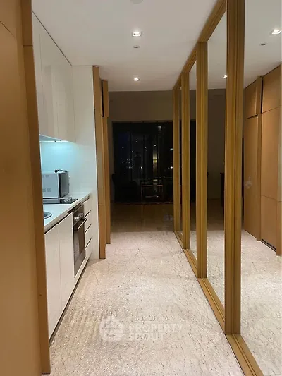 Modern kitchen with sleek design and open layout, featuring built-in oven and stylish cabinetry.