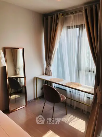 Chic study room with elegant desk and floor-length mirror, bathed in natural light from large window.