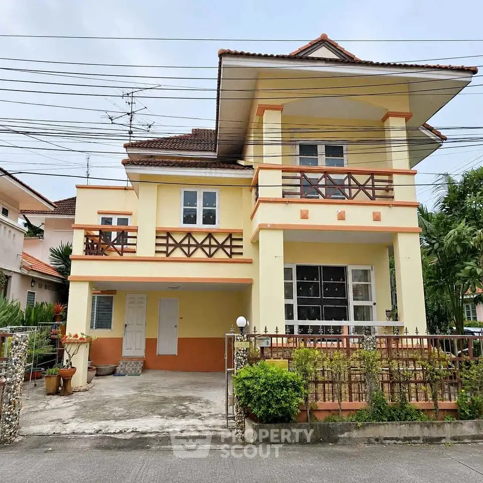 Charming two-story house with balcony and spacious driveway in a serene neighborhood.