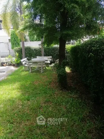 Charming garden area with lush greenery and outdoor seating, perfect for relaxation and entertaining.