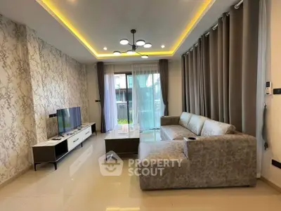 Modern living room with stylish decor and large sectional sofa, featuring elegant lighting and floor-to-ceiling curtains.