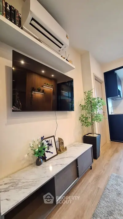Modern living room with wall-mounted TV, air conditioning, and stylish decor