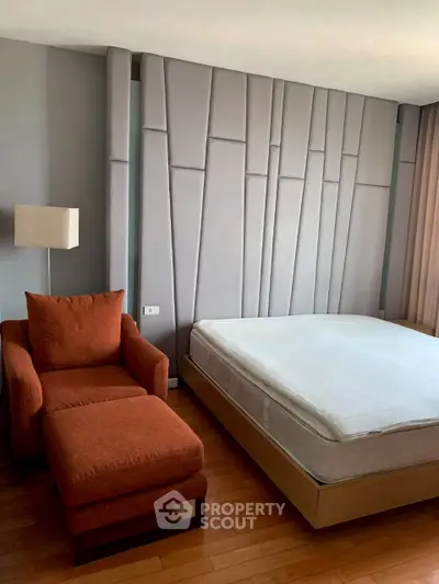 Modern bedroom with stylish accent wall and cozy armchair