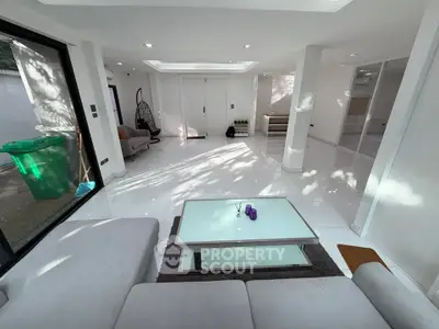 Spacious modern living room with sleek white tiles and cozy seating area.